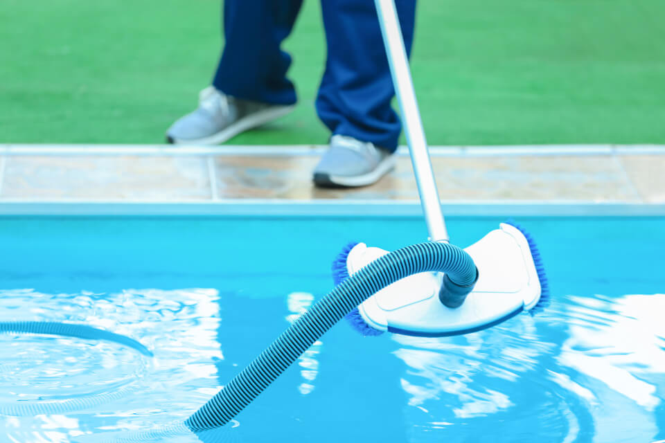 Man cleaning the pool using a device
