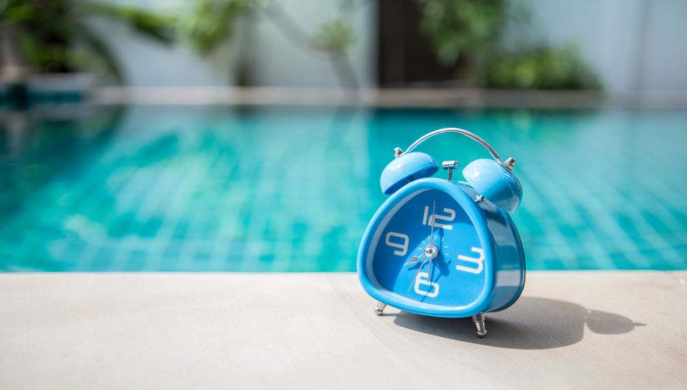 A Blue clock on swimming pool edge.