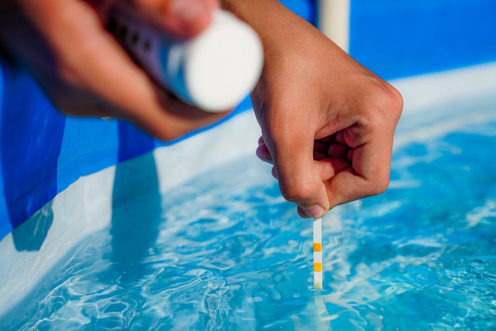 A man checking a pool's pH levels and chemical balance.