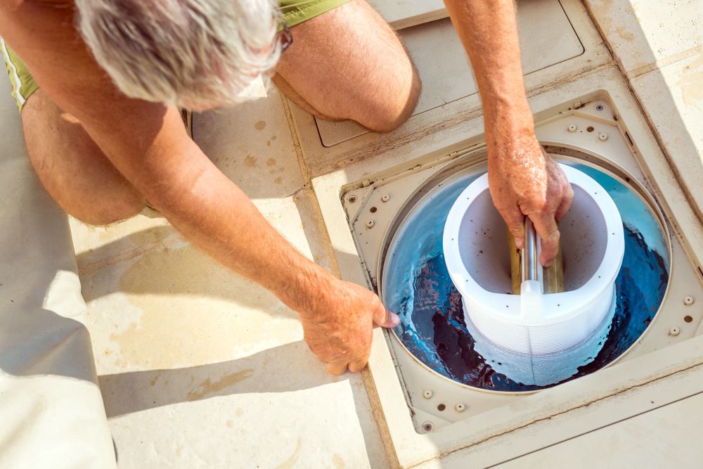 A man cleaning his pool filter and preparing it for the next pool outing.